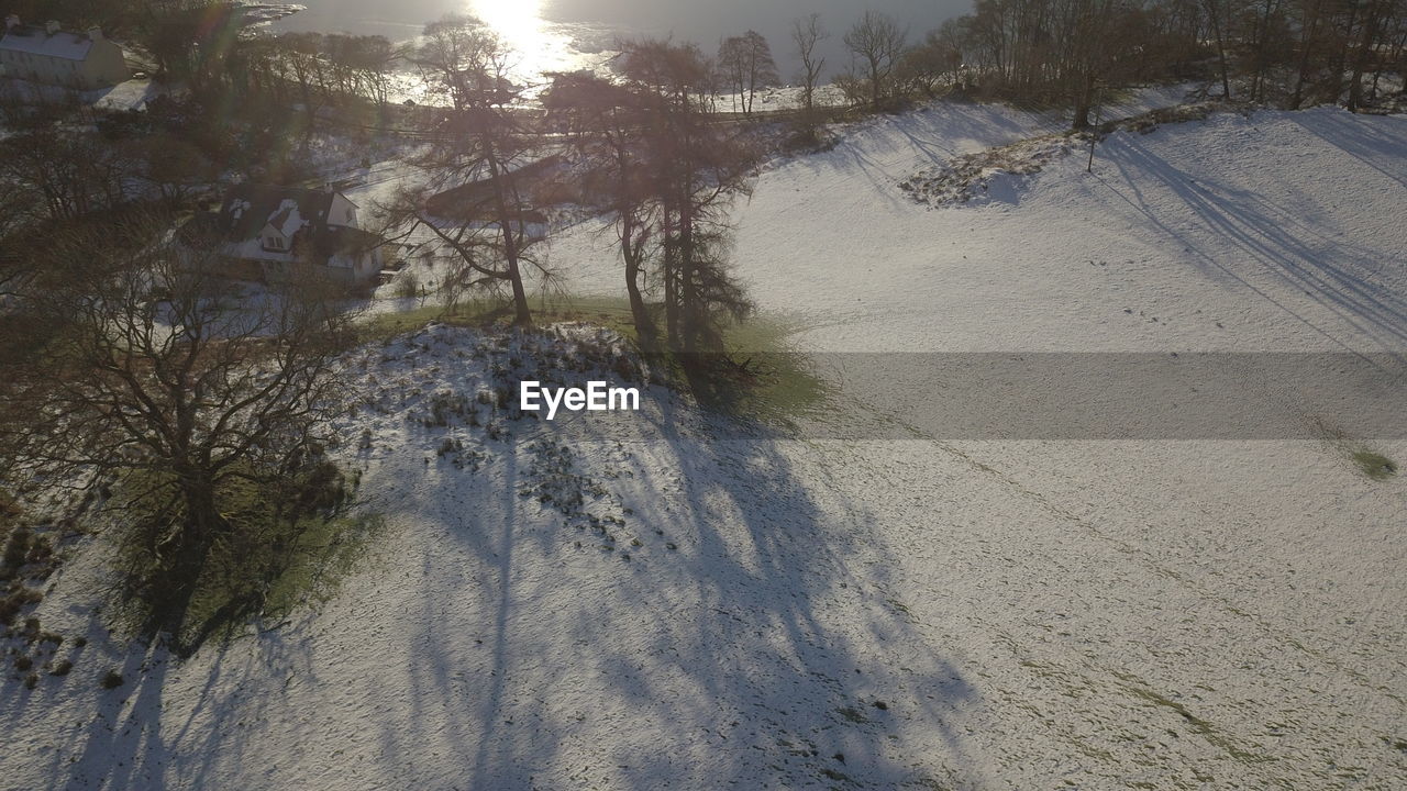 HIGH ANGLE VIEW OF SNOW COVERED LAND DURING WINTER