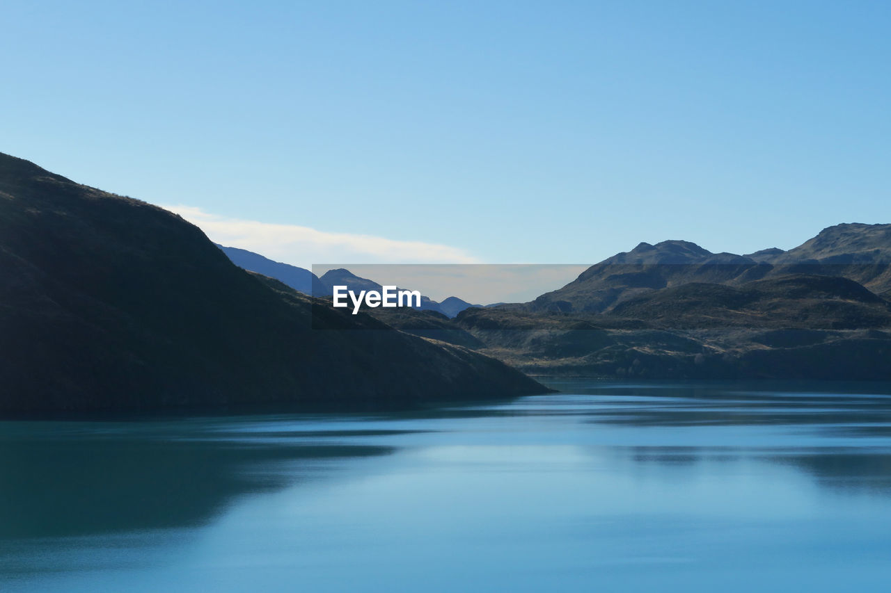 Scenic view of river and mountains against sky