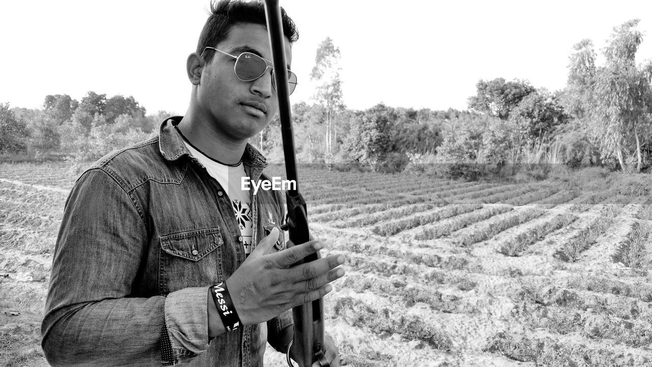 Man holding rifle on field