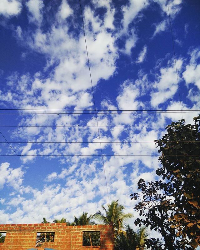 LOW ANGLE VIEW OF POWER LINES AGAINST CLOUDY SKY