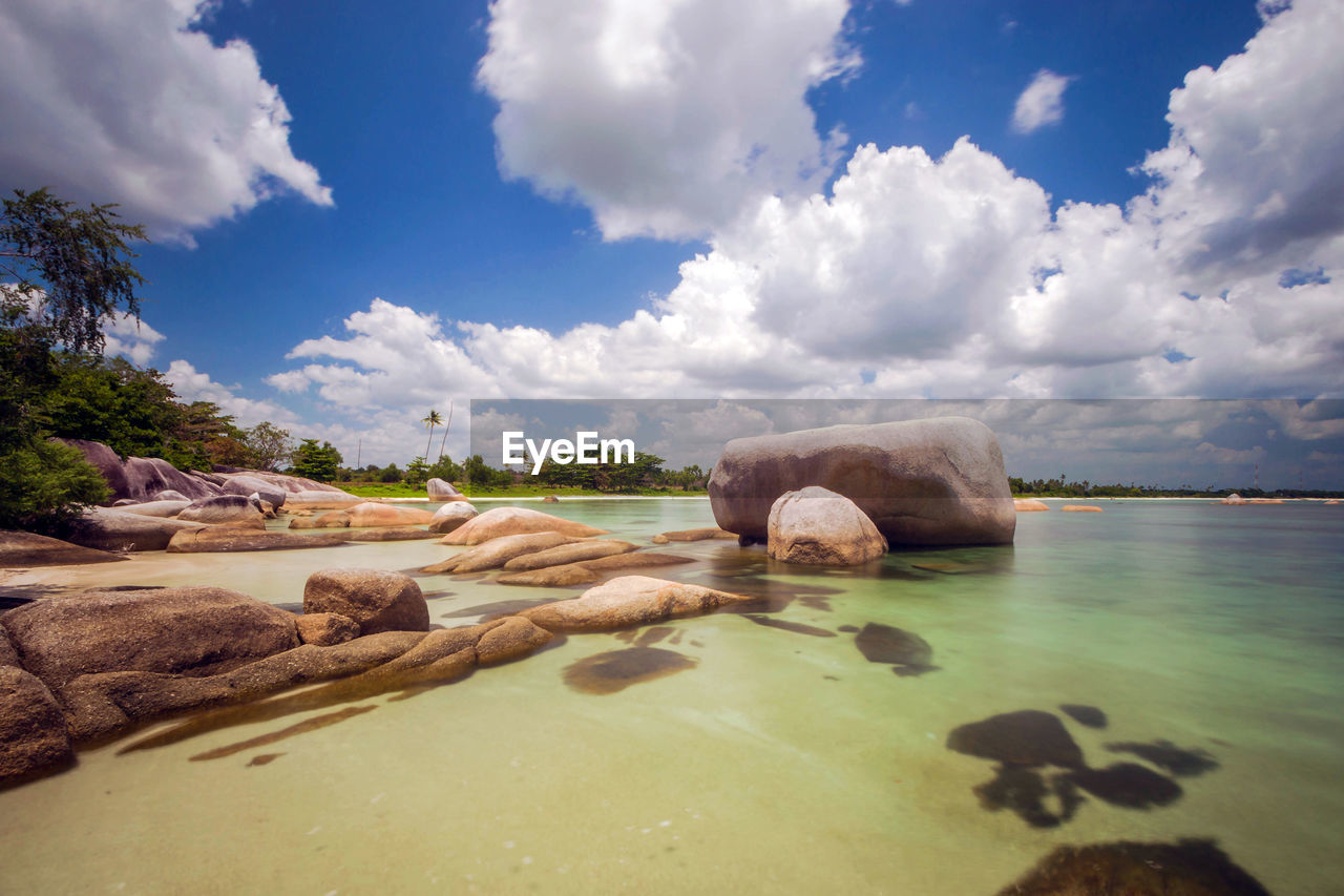 Surface level of rocks on shore against sky