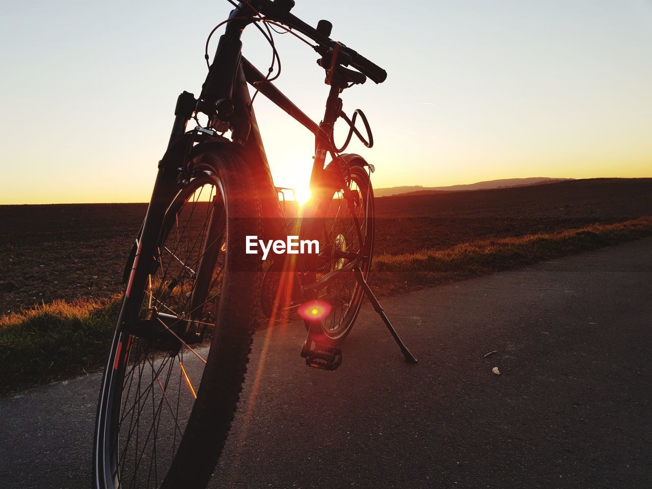 BICYCLE BY ROAD DURING SUNSET