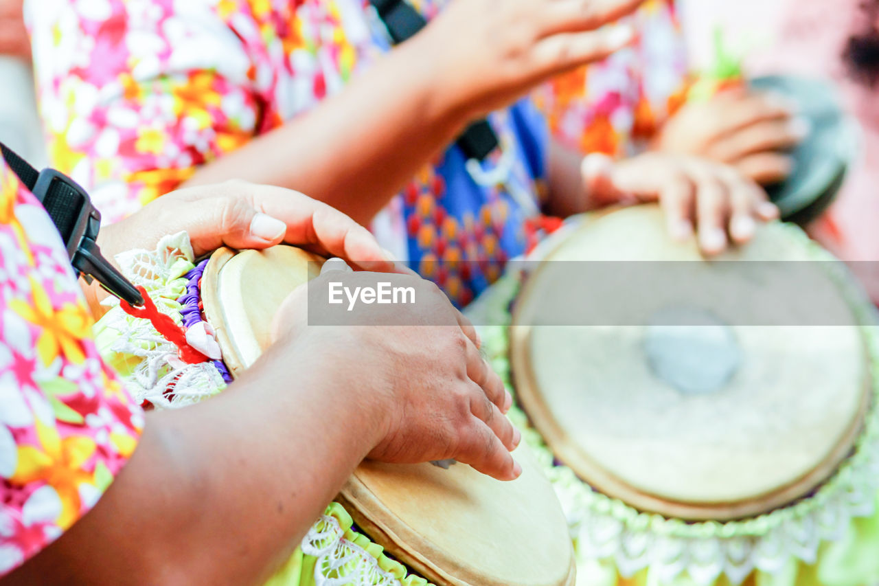 Midsection of people playing djembes during parade