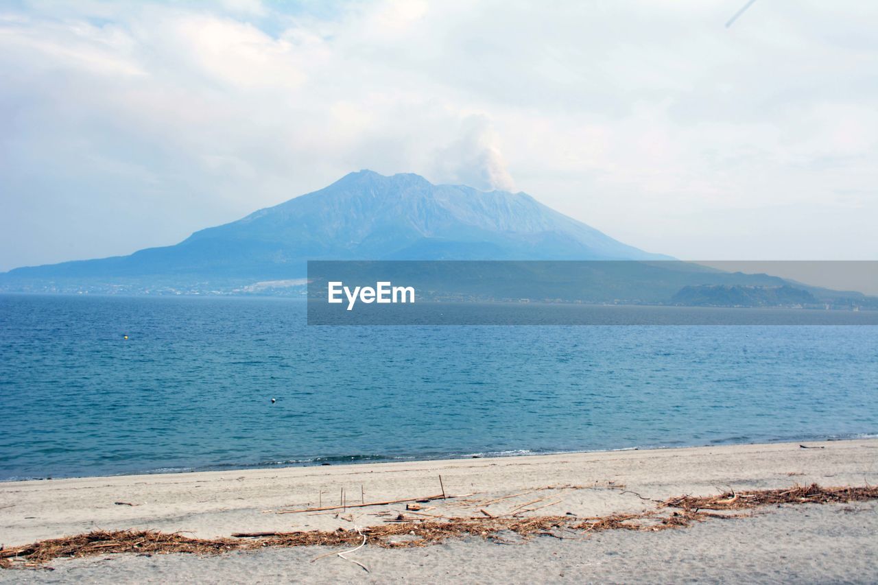 Scenic view of sea and mountains against sky