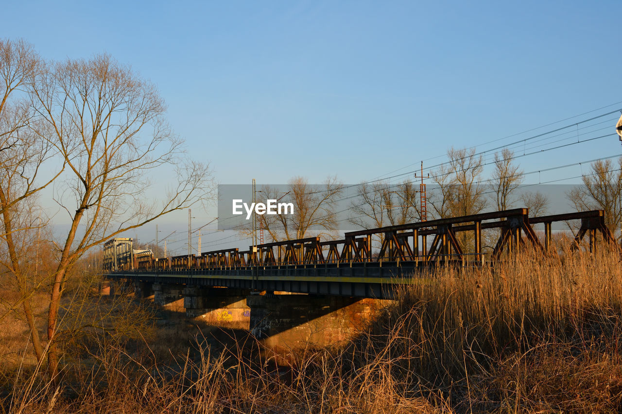 BRIDGE ON FIELD AGAINST SKY