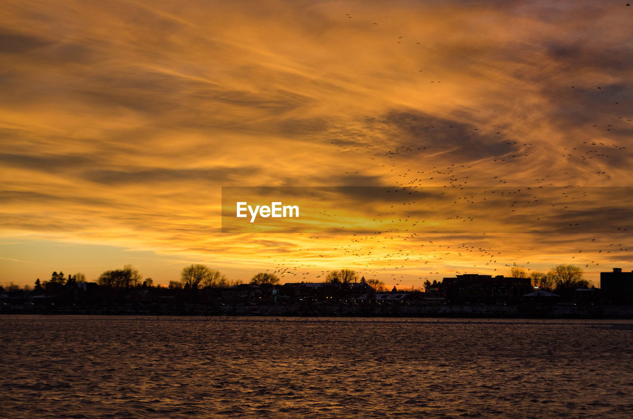 SCENIC VIEW OF LAKE AGAINST ORANGE SKY