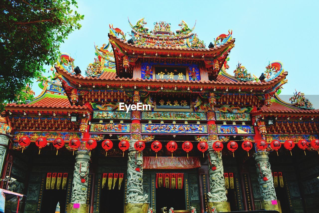 LOW ANGLE VIEW OF TEMPLE AGAINST BUILDING AND SKY