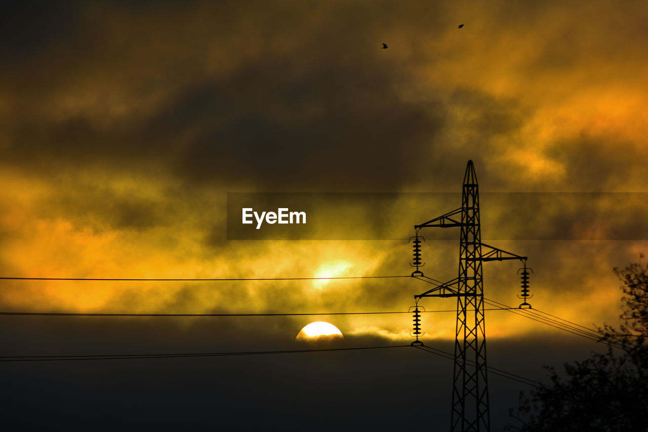 sky, sunset, cloud, technology, electricity, silhouette, cable, sunlight, evening, nature, dusk, electricity pylon, power line, afterglow, sun, power supply, no people, light, power generation, dramatic sky, orange color, beauty in nature, darkness, low angle view, outdoors, overhead power line, built structure, architecture, scenics - nature, electrical supply, communication