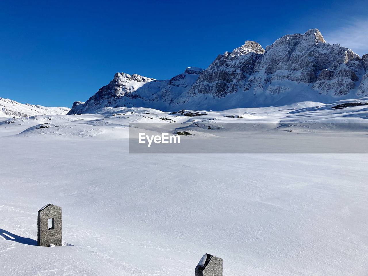 Scenic view of snowcapped mountains against clear blue sky