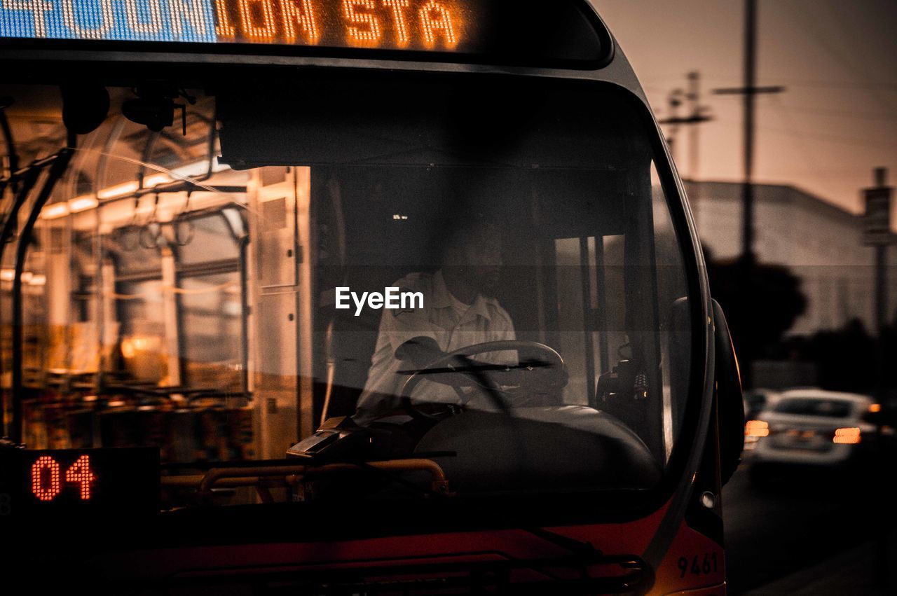 CLOSE-UP OF CAR WINDOW WITH CITY IN BACKGROUND