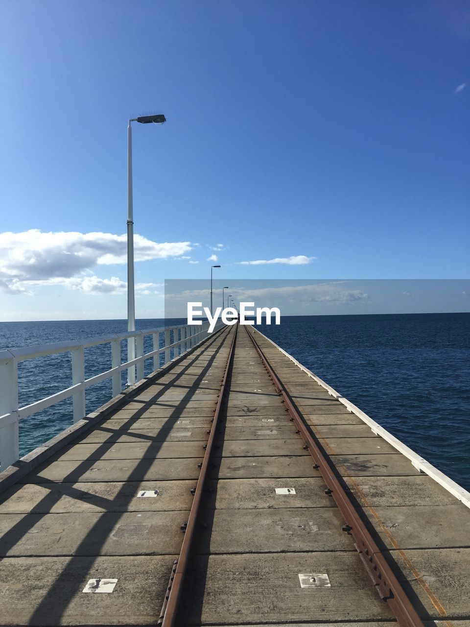 View of pier over sea against blue sky