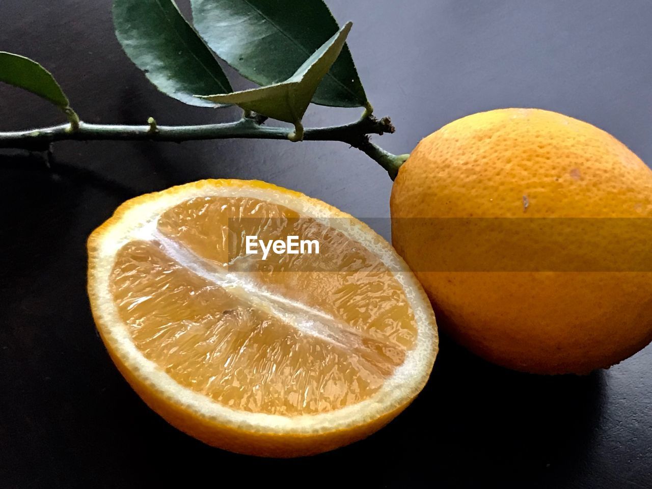 CLOSE-UP OF LEMON SLICE AGAINST GRAY BACKGROUND