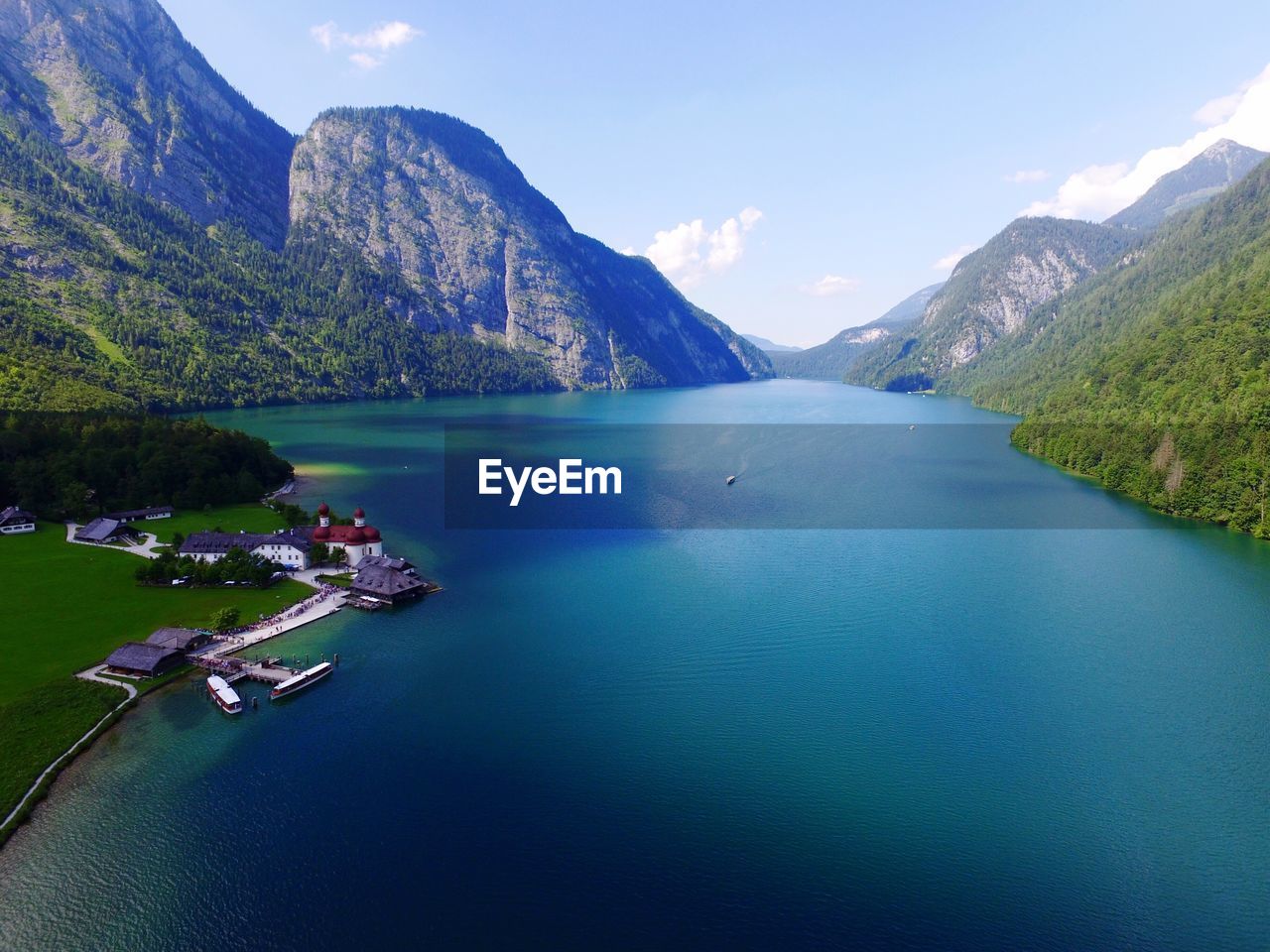 Scenic view of building by river and lush mountain