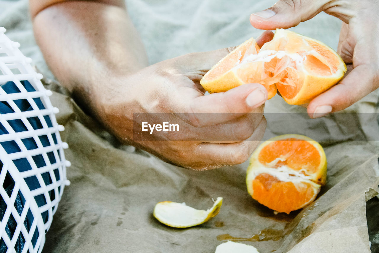 Close-up mid section of man holding orange