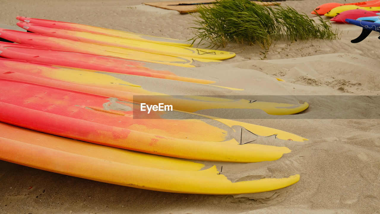 yellow, beach, sand, surfing equipment, land, nature, surfboard, sports equipment, day, water, paddle, high angle view, outdoors, boat, vacation, leisure activity, kayak, holiday, trip, vehicle, childhood, summer