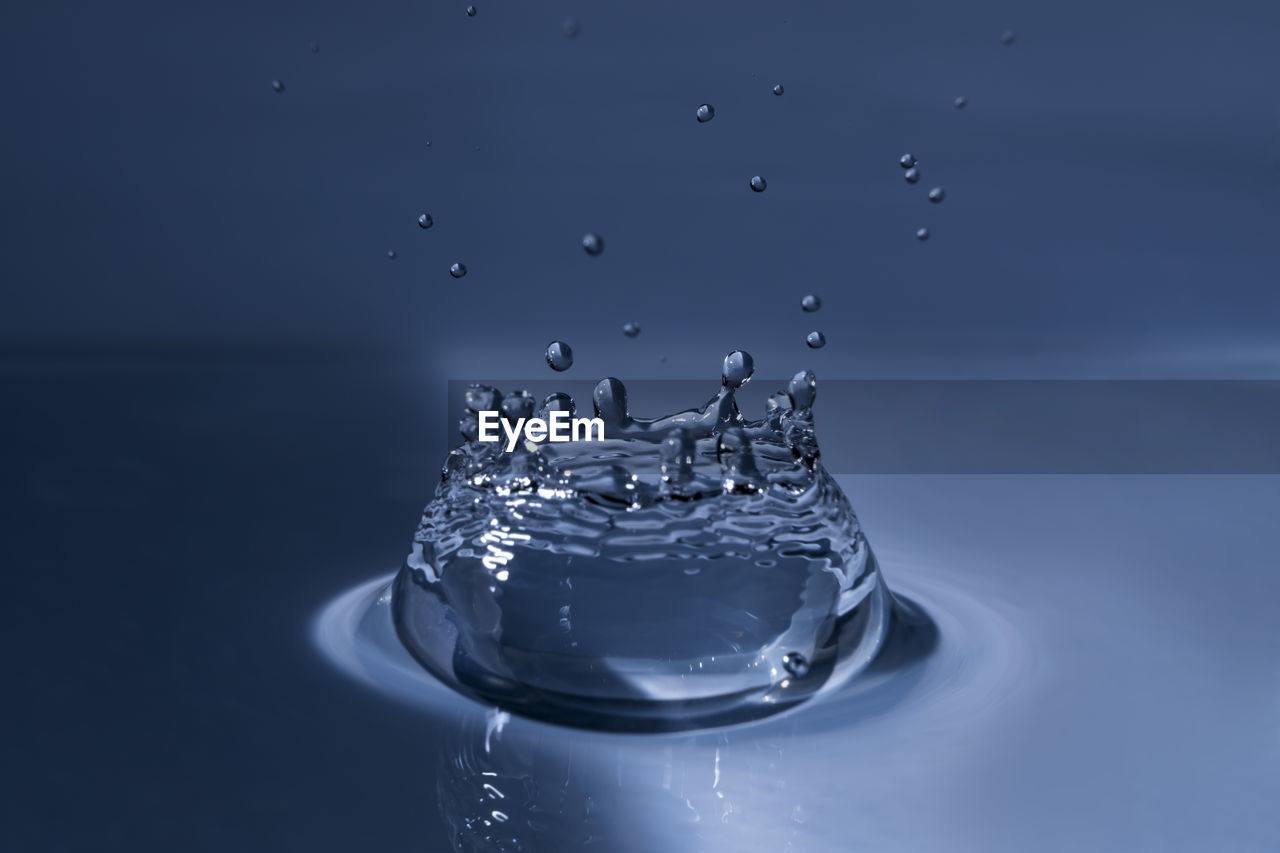 Close-up of splashing water drop hitting water surface