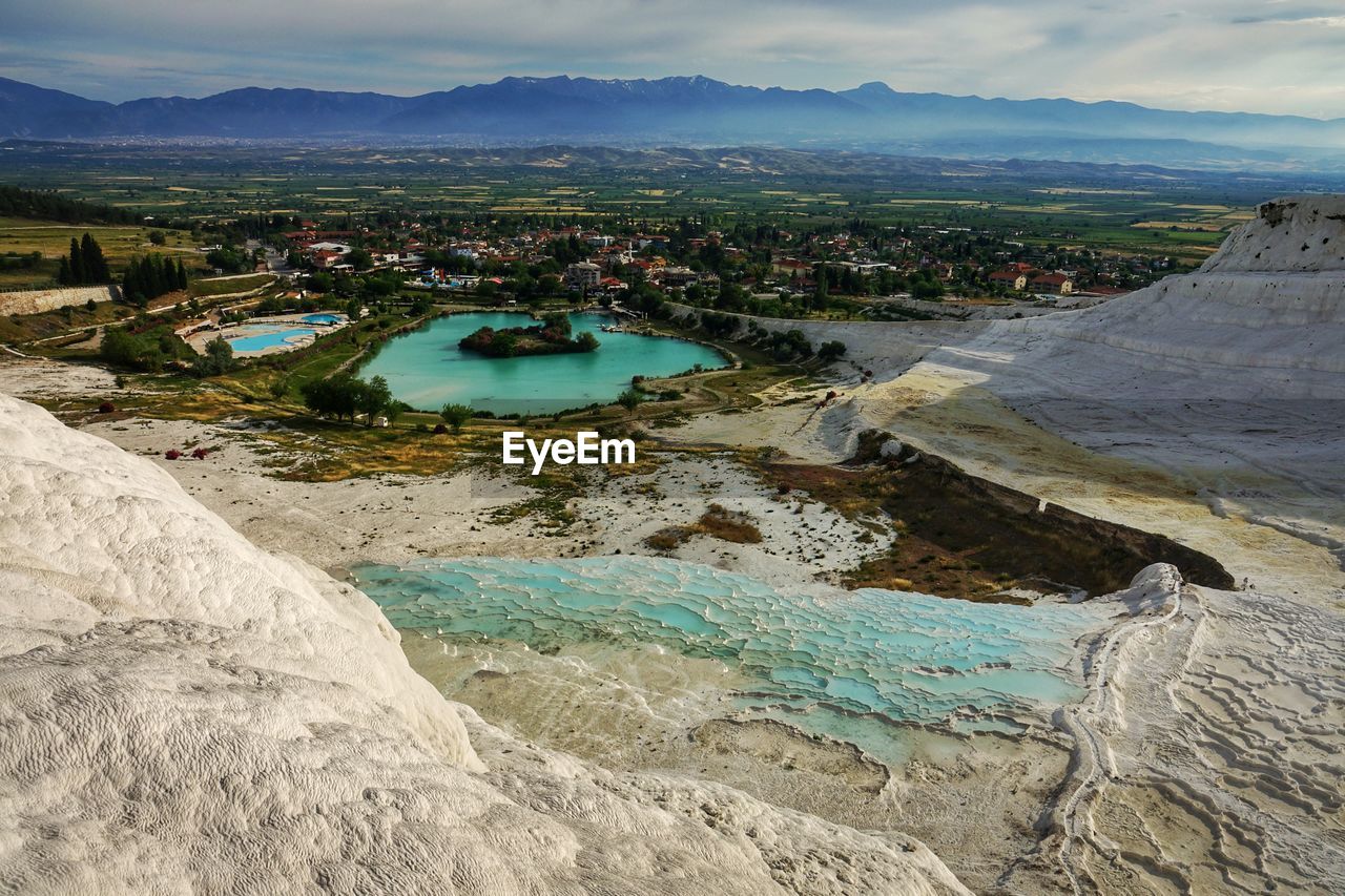 Scenic view of river by mountains against sky