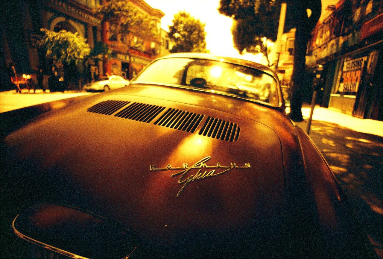 CLOSE-UP OF CARS ON STREET AGAINST SKY