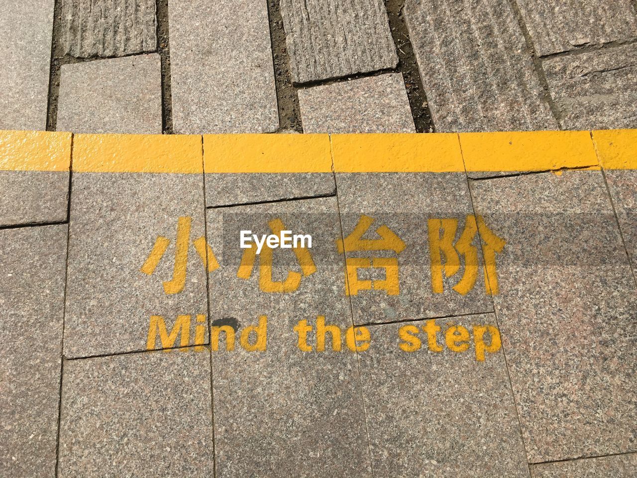 High angle view of yellow text on footpath