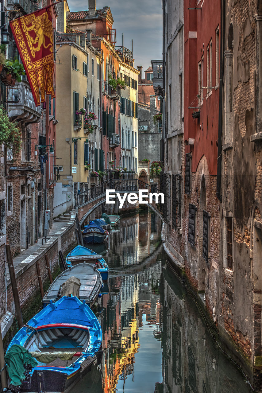 CANAL AMIDST BUILDINGS AGAINST SKY