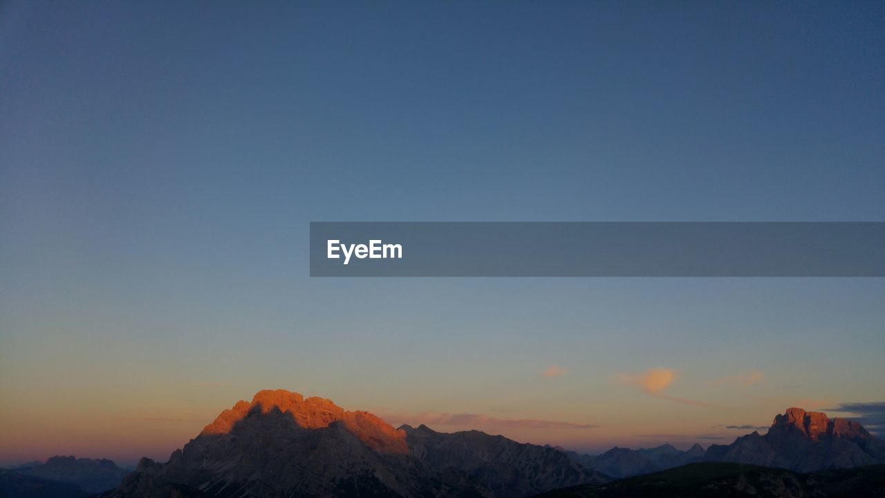 Scenic view of mountains against clear sky during sunset