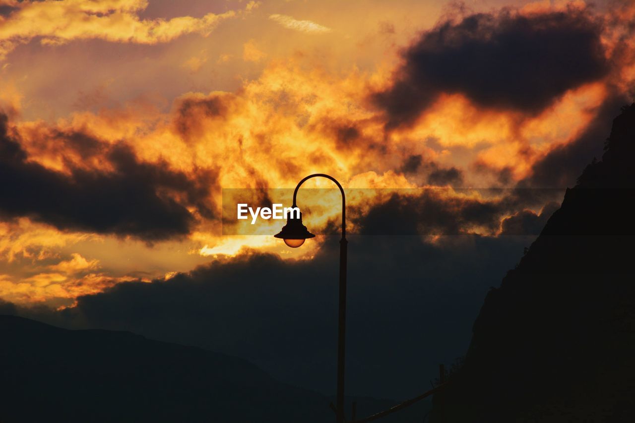 Low angle view of street light against orange sky