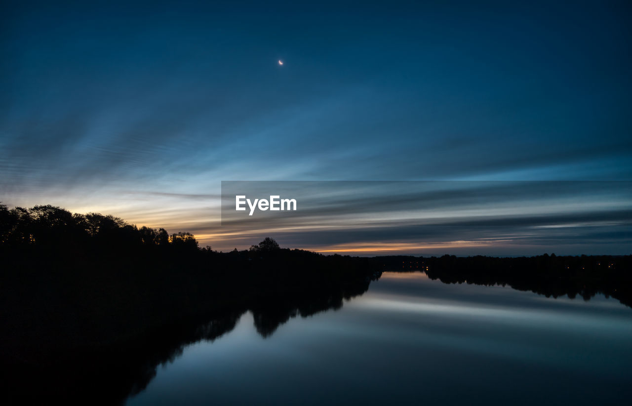 Scenic view of lake against sky at sunset