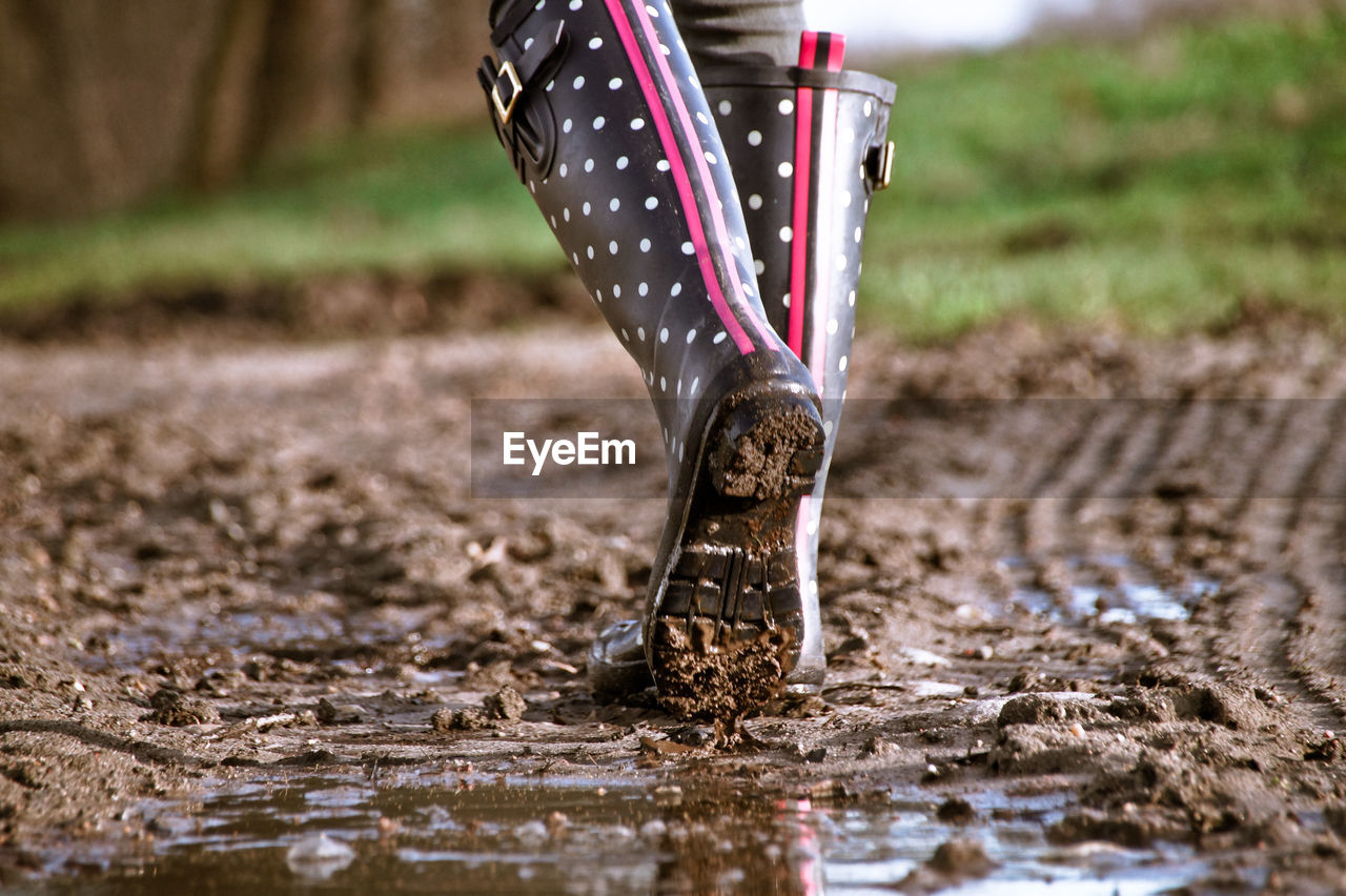 LOW SECTION OF WOMAN IN PUDDLE