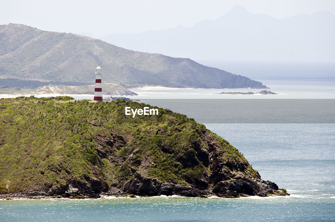 LIGHTHOUSE BY SEA AGAINST SKY