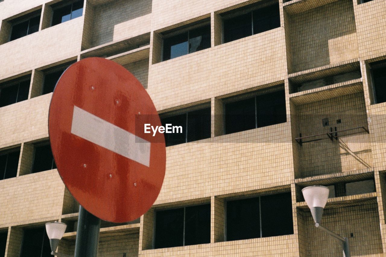 LOW ANGLE VIEW OF ROAD SIGN BY BUILDING