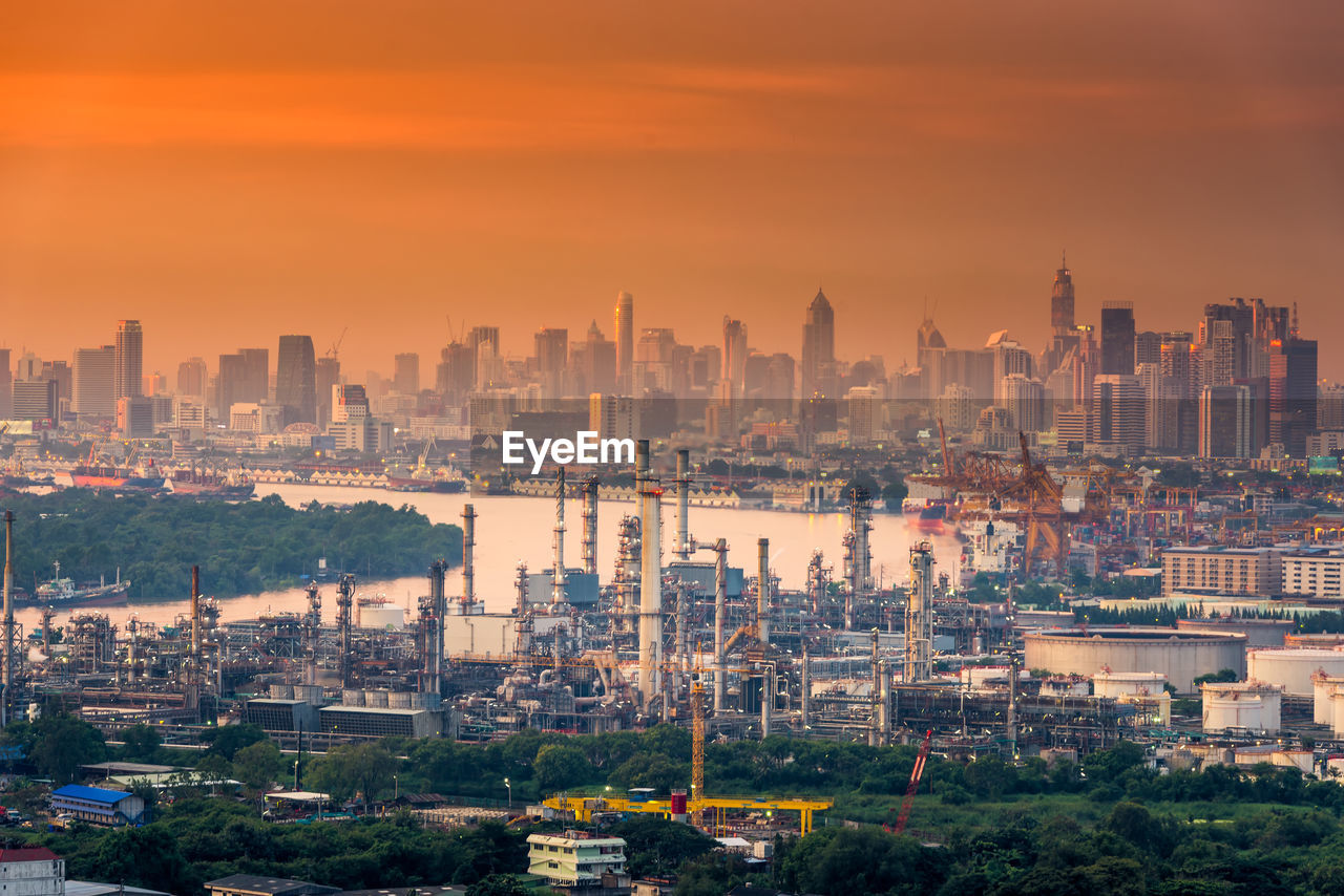 HIGH ANGLE VIEW OF BUILDINGS AGAINST ORANGE SKY