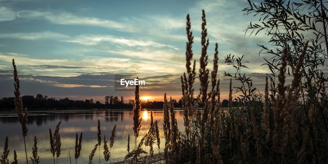 Scenic view of lake against sky at sunset