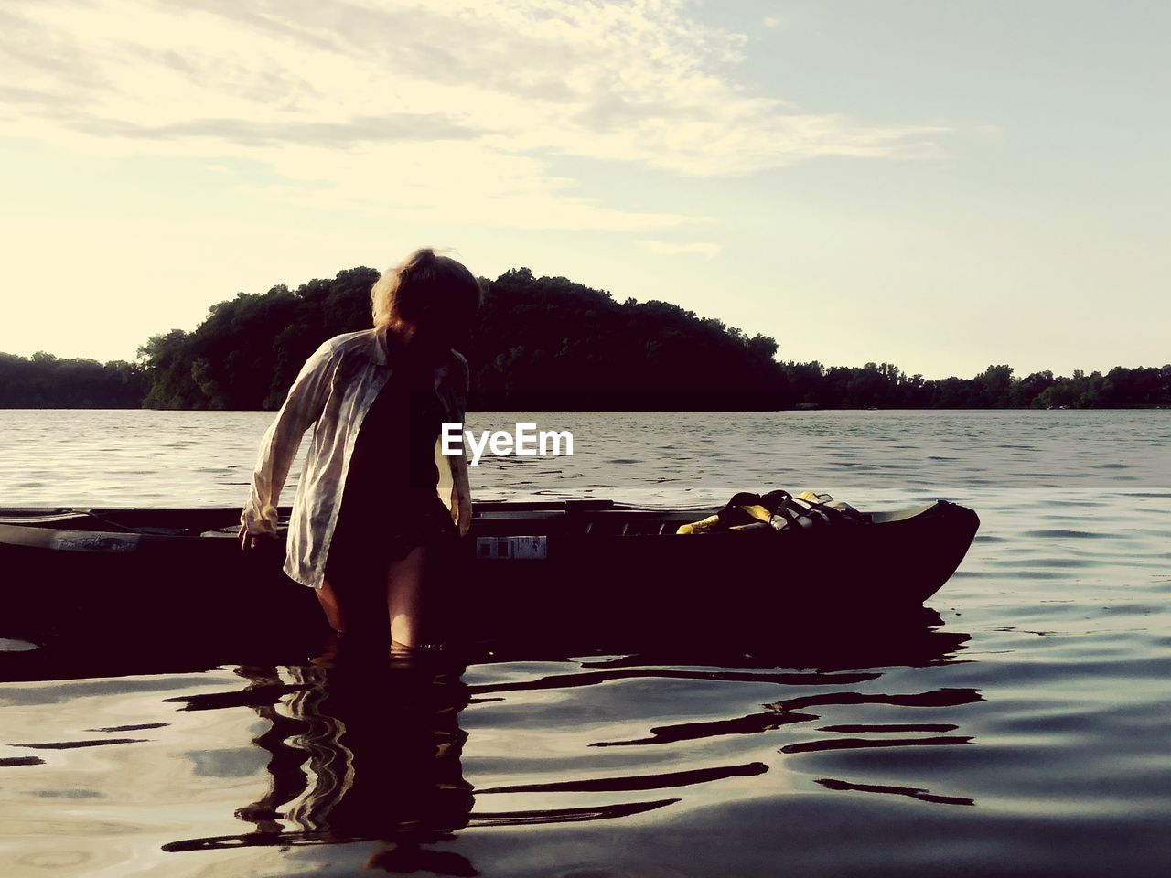 WOMAN STANDING ON LAKE AGAINST SKY