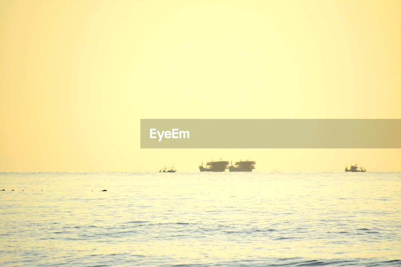 BOAT SAILING ON SEA AGAINST CLEAR SKY