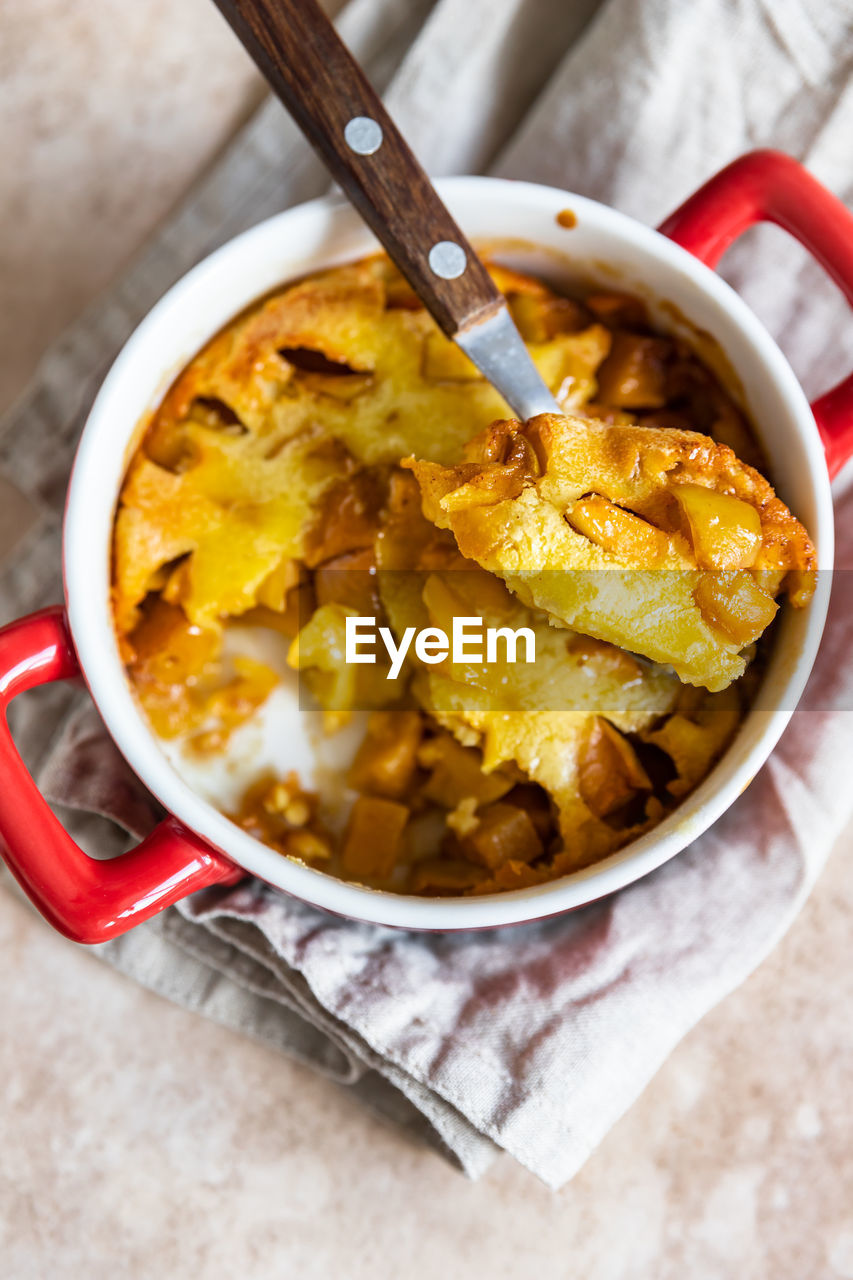 Dutch baby pancake with apples served with honey in ceramic baking dish. delicious sweet breakfast.