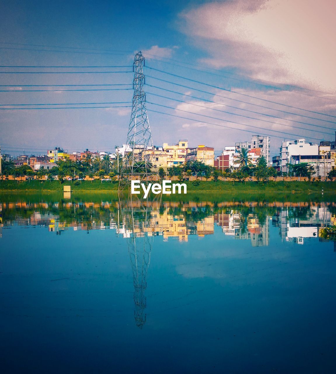 REFLECTION OF BUILDING IN LAKE AGAINST SKY