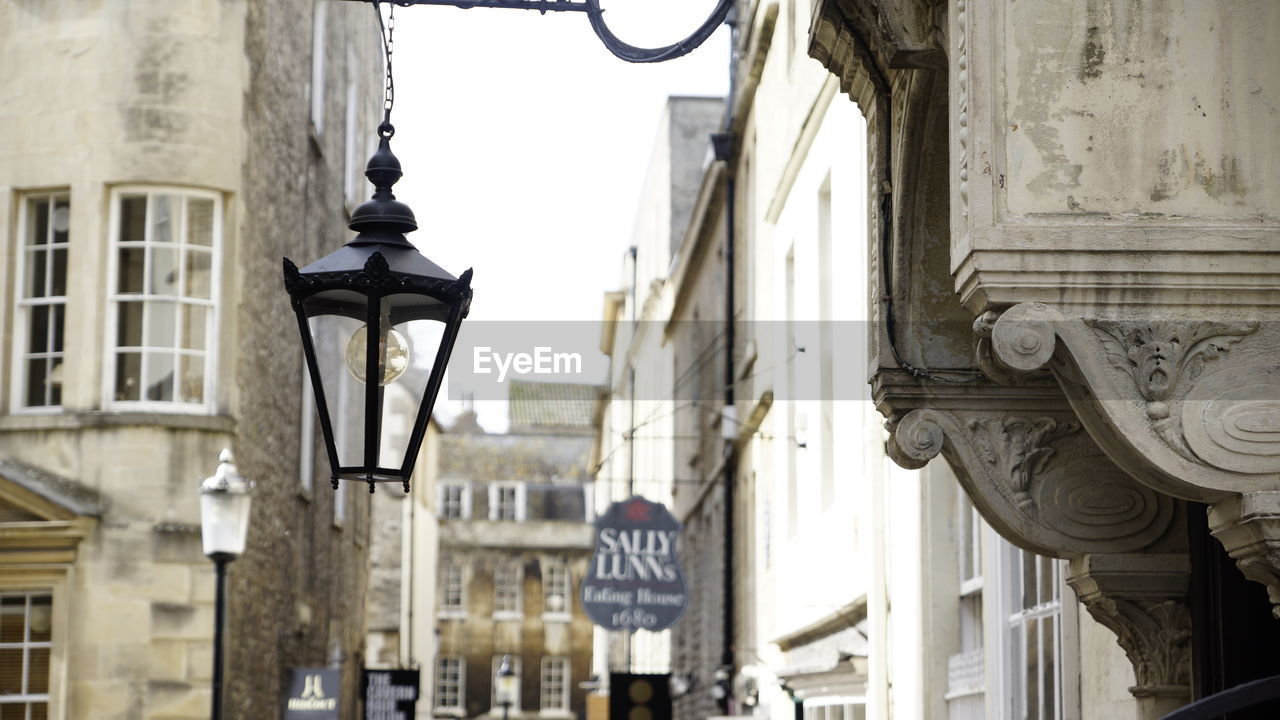 LOW ANGLE VIEW OF STREET LIGHT AGAINST BUILDINGS IN CITY