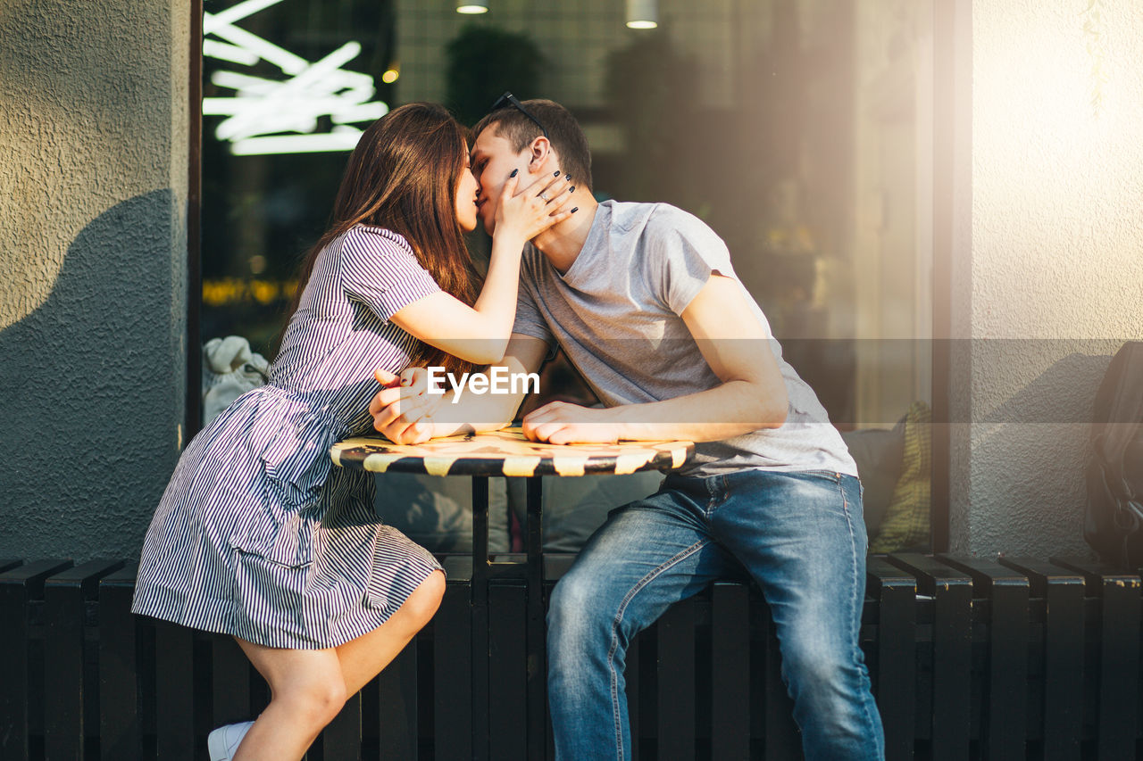 Young couple kissing at outdoor cafe in city