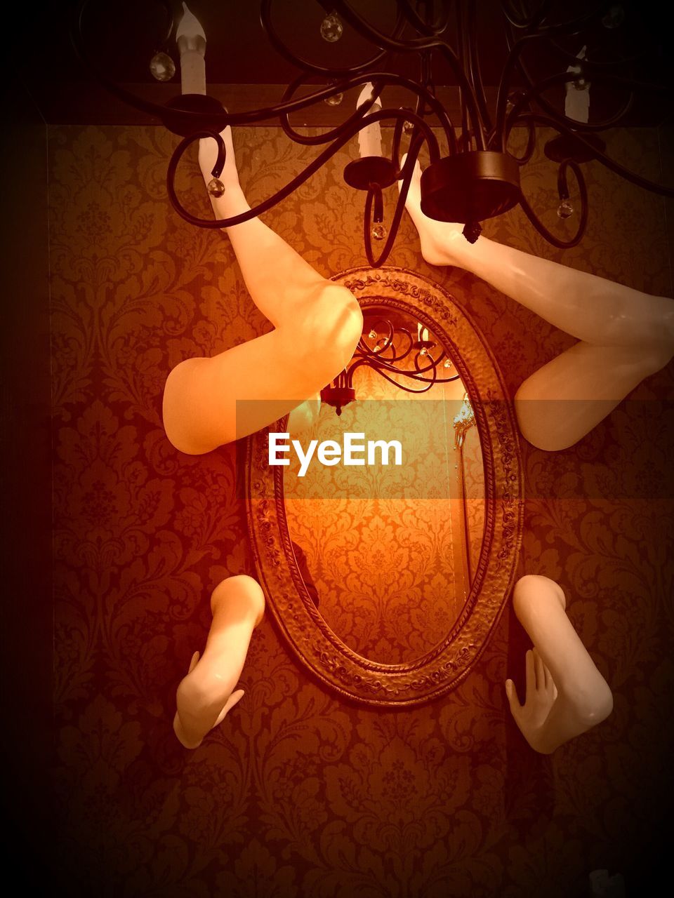 Mirror and broken mannequins on wall at home