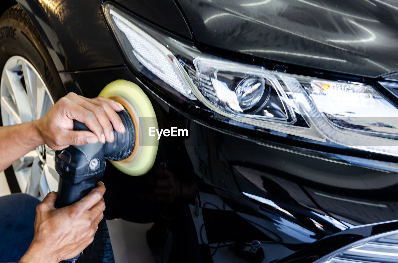 MIDSECTION OF MAN HOLDING CAR