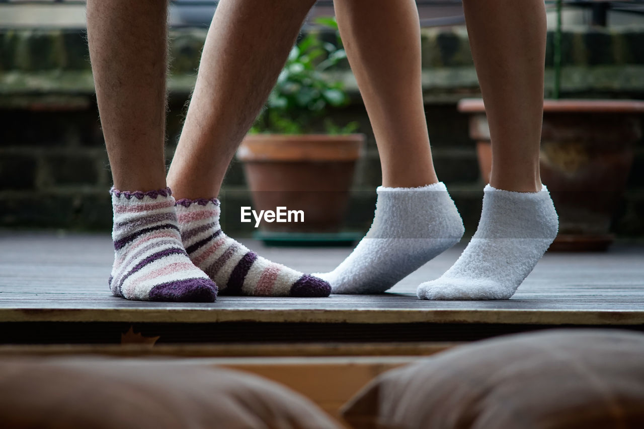 Low section of couple wearing socks at patio