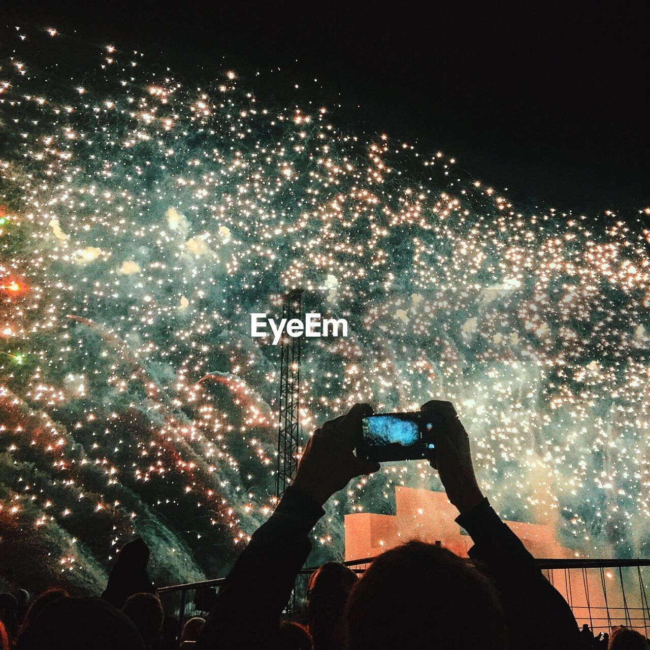 Man photographing fireworks from smart phone at night