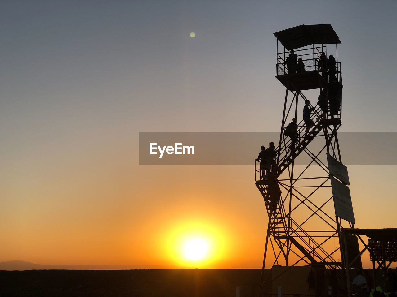 LOW ANGLE VIEW OF COMMUNICATIONS TOWER AGAINST SKY DURING SUNSET