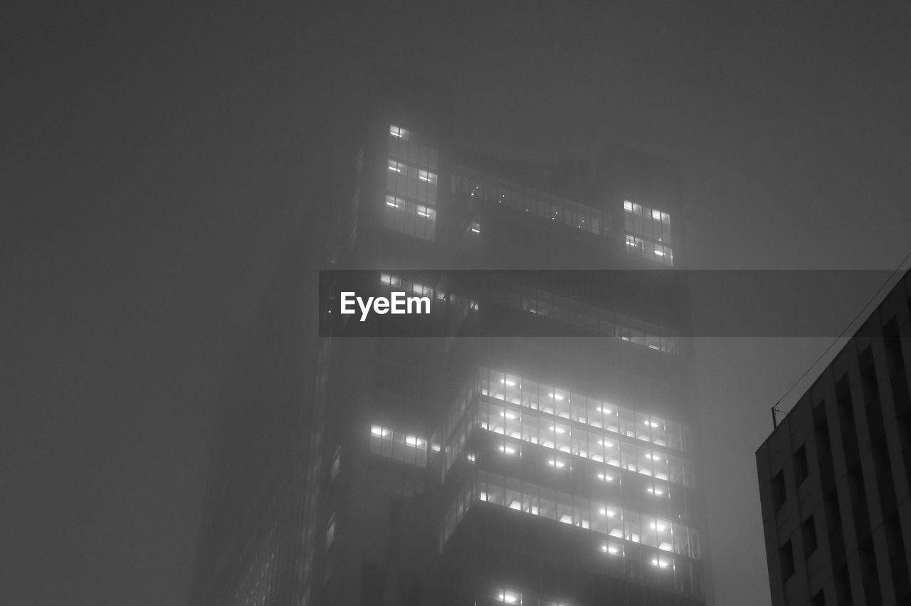 LOW ANGLE VIEW OF BUILDINGS IN CITY AT NIGHT