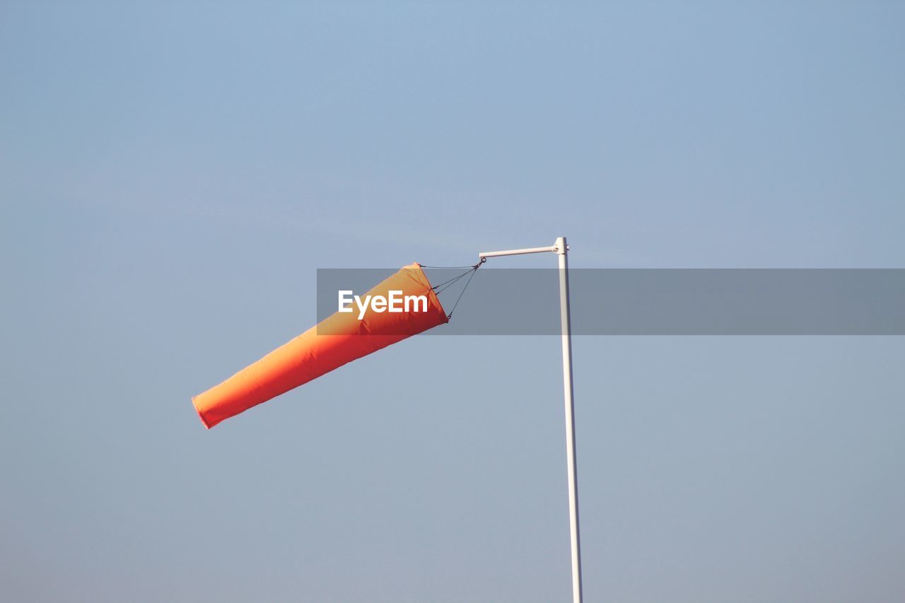 Low angle view of wind sock against clear sky