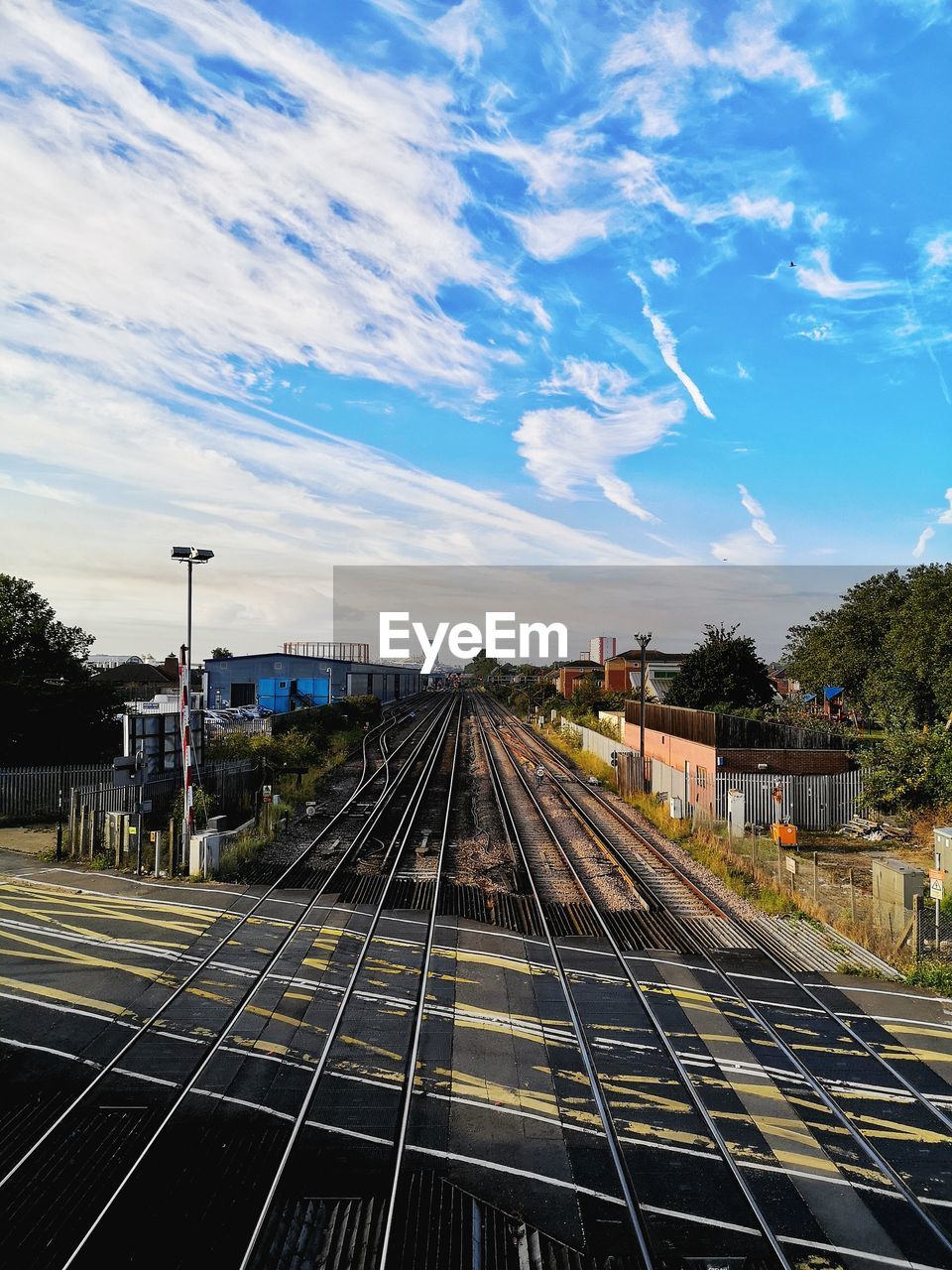 Railroad tracks in city against sky