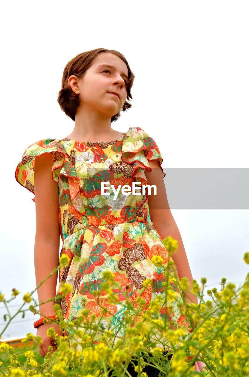 Low angle view of girl standing on field