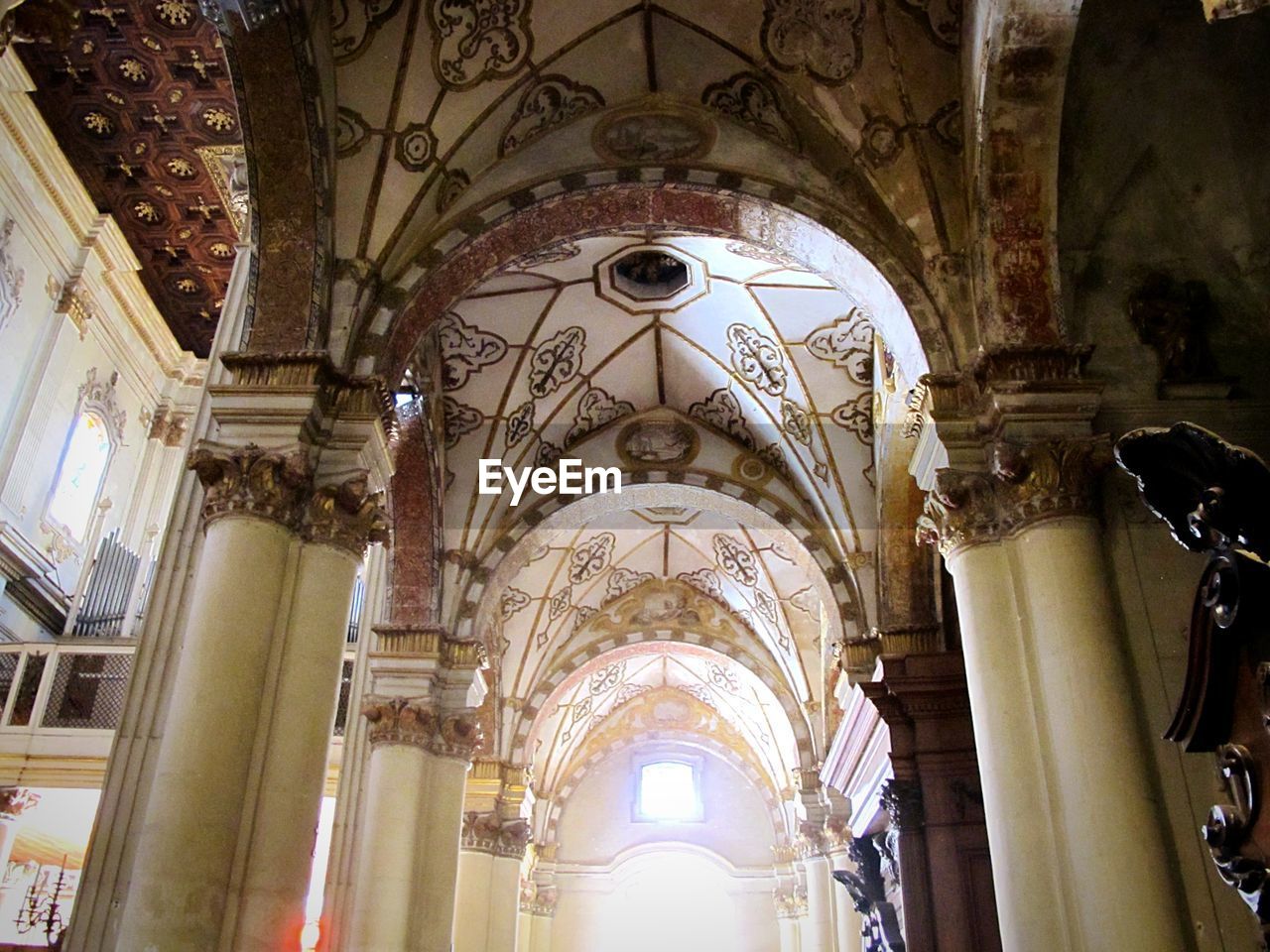 LOW ANGLE VIEW OF CHURCH WITH ARCHED STRUCTURE