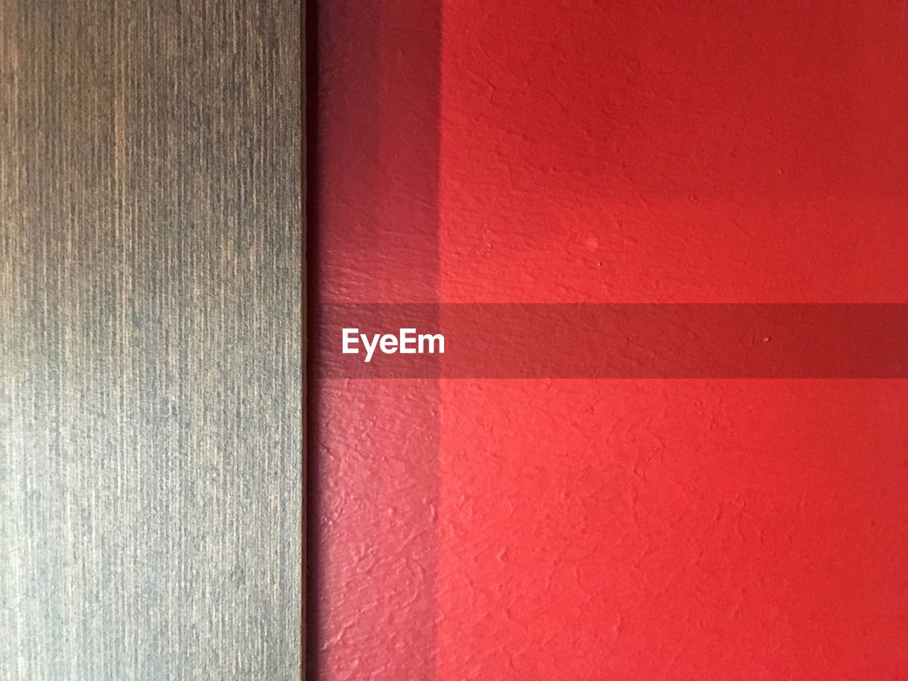 Close-up of wooden door against red wall