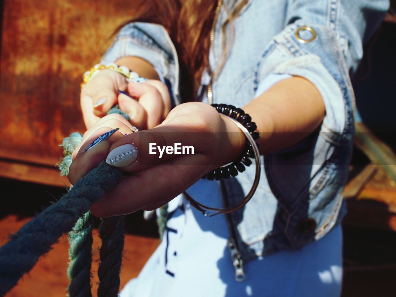 Midsection of young woman pulling rope
